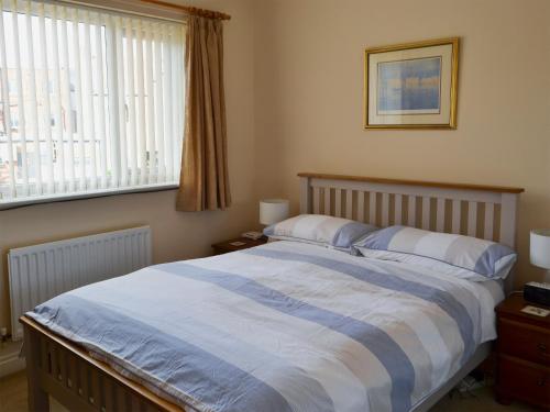 a bedroom with a bed with a blue and white comforter at Millside in Morpeth
