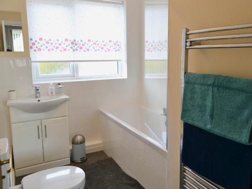 uma casa de banho com uma banheira, um WC e um lavatório. em Millside em Morpeth