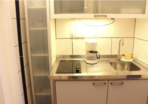 a small kitchen with a sink and a blender on a counter at a-partment • Köln- Mediapark in Cologne