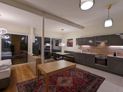eine Küche und ein Wohnzimmer mit einem Tisch im Zimmer in der Unterkunft Luxurious & lovely vacation home in Prüfingberg