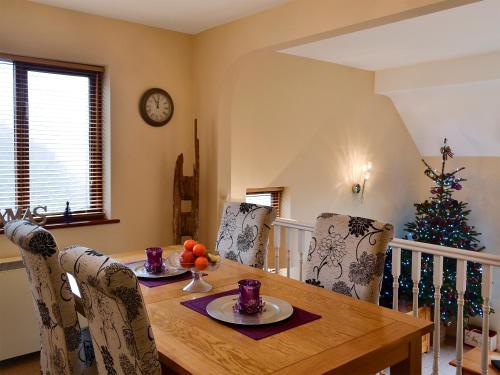 a dining room with a table and a christmas tree at Morlais - Hw7599 in Llanaber