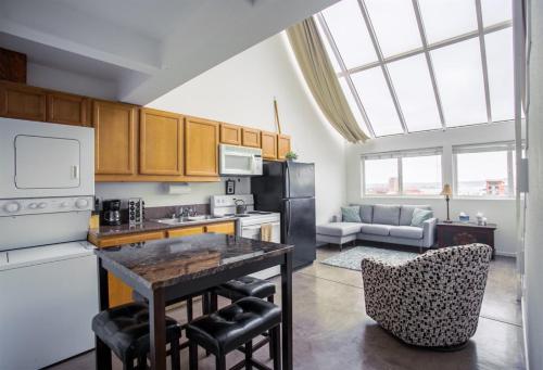 a kitchen with a refrigerator and a table and chairs at Little Italy Modern Lofts in San Diego