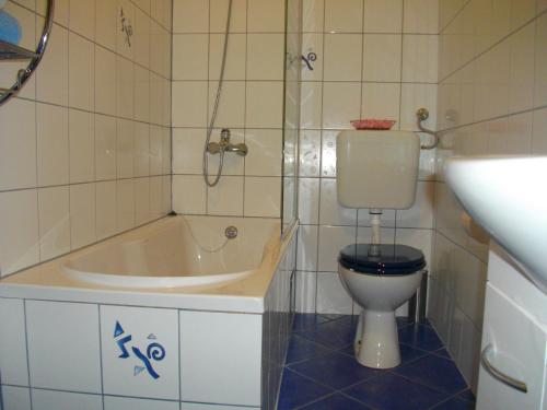 a bathroom with a tub and a toilet and a sink at Luna Apartments in Trogir
