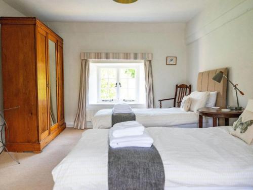 a hotel room with two beds and a window at Old Orchard Cottage in Haydon