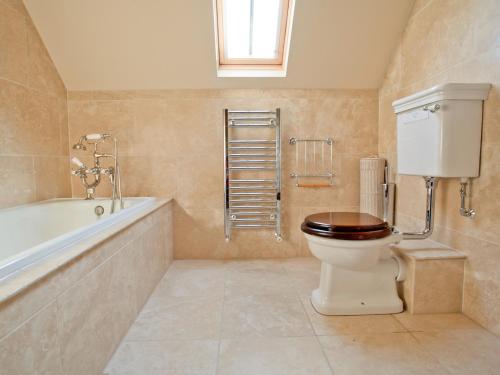 a bathroom with a toilet and a bath tub at Heathery Edge Farm in Matfen