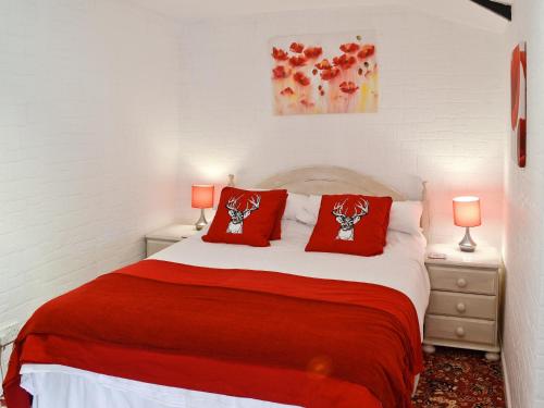Un dormitorio con una cama con almohadas rojas. en Gamekeepers Apt - Cv20, en Saint Cleer