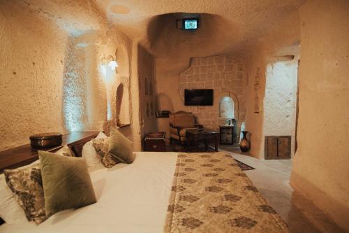 a bedroom with a bed in a room with a tv at Hu of Cappadocia - Special Class in Uchisar