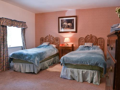 Duas camas num quarto com paredes cor-de-rosa em The Granary em Eggleston