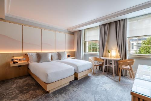 a hotel room with a bed and a table and chairs at The Prince Akatoki London in London