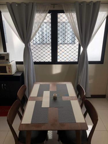 a dining room table with two chairs and a window at Camella Northpoint in Davao City