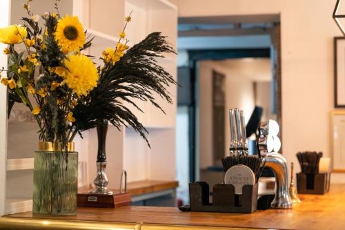 a vase filled with yellow flowers on a counter at The Ancient Unicorn in Barnard Castle