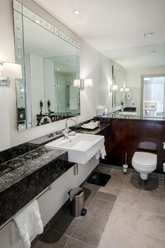 a bathroom with a sink and a toilet and a mirror at The Prince Akatoki London in London