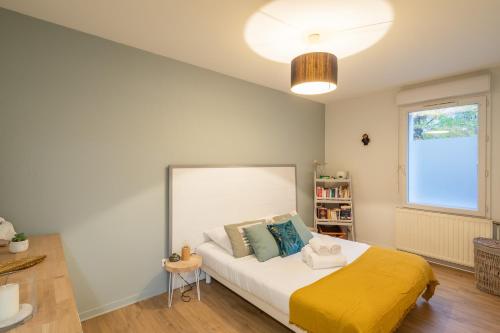 sypialnia z łóżkiem z żółtym kocem w obiekcie Sérénité - 2 chambres - Calme et Verdure w mieście Nantes