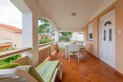 a balcony with a table and chairs in a house at Apartmani Luka in Vir