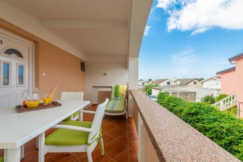 a balcony with a table and chairs and a view at Apartmani Luka in Vir