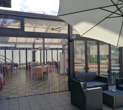 a restaurant with tables and chairs and an umbrella at HOTEL RISTORANTE DELLE VALLI in Germagnano