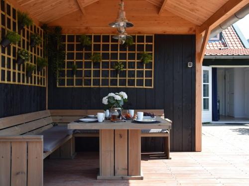 una mesa de madera con flores en el patio en Comfortable holiday home in Schoondijke, en Schoondijke