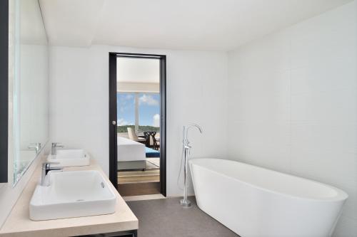 a white bathroom with a tub and a sink at Courtyard by Marriott Navi Mumbai in Navi Mumbai