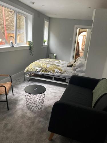 a bedroom with a bed and a couch at Teviot View Apartment in Hawick