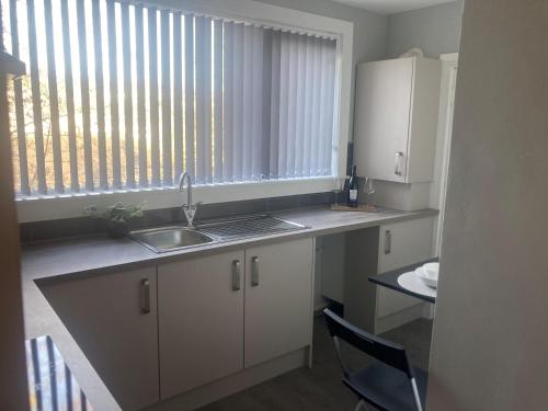 a small kitchen with a sink and a window at Teviot View Apartment in Hawick