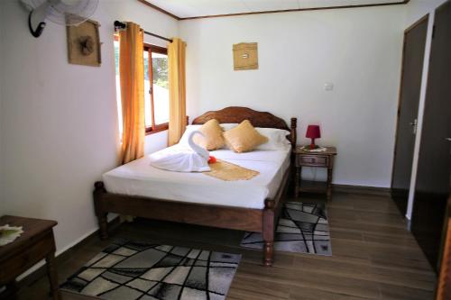 a bedroom with a bed with a swan on it at Tannette Villa in La Digue