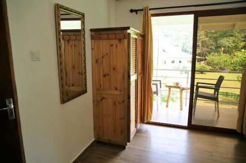 a room with a door and a mirror and a table at Tannette Villa in La Digue