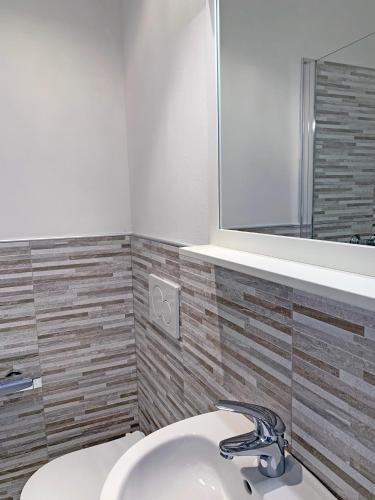 a bathroom with a white sink and a mirror at Hotel Alessandra in Garda