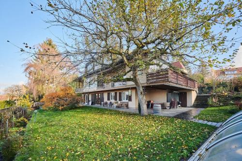 une maison avec un arbre en face d'une cour dans l'établissement zeitweise[.]haus Denkerhaus und Stadtoase, à Weingarten