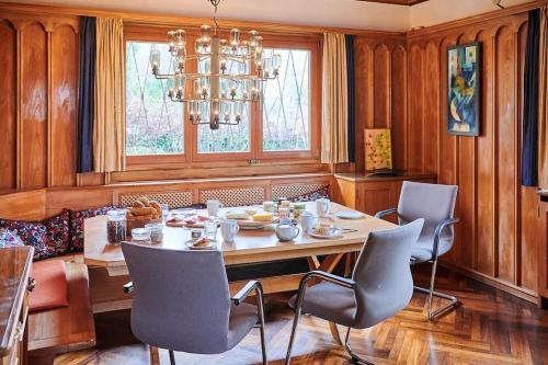 a dining room with a table and chairs and a chandelier at zeitweise[.]haus Denkerhaus und Stadtoase in Weingarten