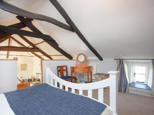 una camera con un letto bianco e una coperta blu di The Annexe - Tbh a Crackington Haven