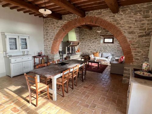 a kitchen and living room with a large table and chairs at Villa Gosparini in Lisciano Niccone