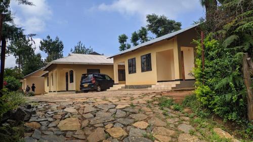 une maison avec une voiture garée devant elle dans l'établissement Usambara Green Forest, à Lushoto