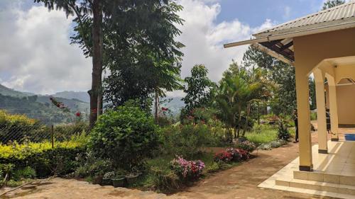 une terrasse couverte d'une maison avec un jardin fleuri dans l'établissement Usambara Green Forest, à Lushoto