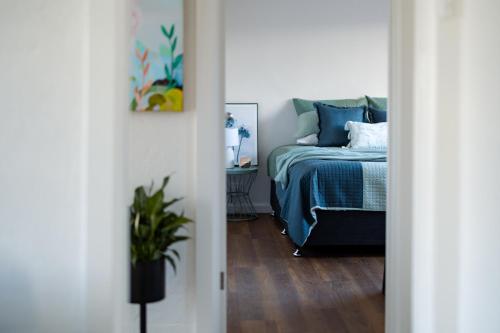 a bedroom with a bed and a potted plant at Art deco inner city comfort in Bendigo