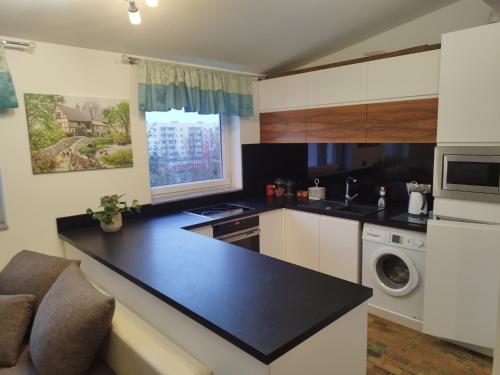 eine Küche mit einer schwarzen Arbeitsplatte in einem Zimmer in der Unterkunft Apartament z widokiem Słubice in Słubice