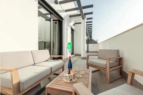 a living room with a couch and a table at Uxama Sevilla Luxury Penthouse en Triana - Terraza y parking privados - piscina in Seville