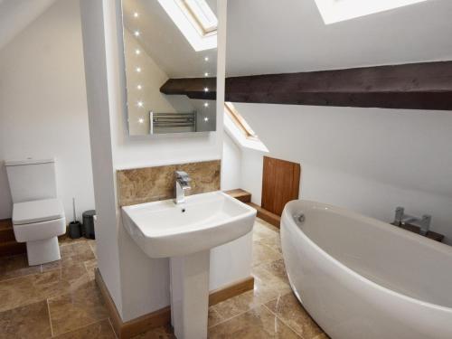 uma casa de banho com um lavatório e uma banheira em Morton Grange Coach House - E5557 em Ellesmere
