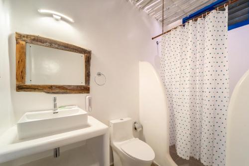 a white bathroom with a sink and a toilet at Conch Resort Luxury Private Pool Suites in Puducherry