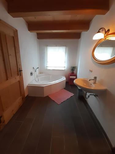 ein Badezimmer mit einer Badewanne und einem Waschbecken in der Unterkunft Sonnleit'n Zimmer 1 in Abtenau