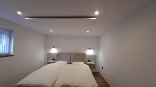 a white bedroom with a large bed in a room at Villa Fantastica Apartments in Mysłakowice