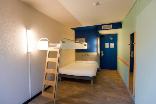 a bunk bed in a room with a ladder at ibis budget Albertville in Gilly-sur-Isère