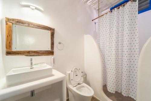 a white bathroom with a sink and a toilet at Conch Resort Luxury Private Pool Suites in Puducherry