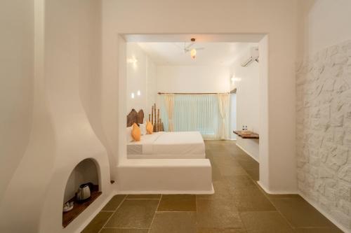 a white room with a bed and a fireplace at Conch Resort Luxury Private Pool Suites in Puducherry