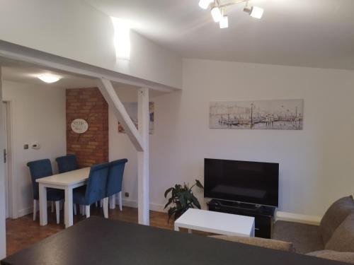Una sala de estar con una mesa y un televisor. en Apartament z widokiem Słubice, en Słubice