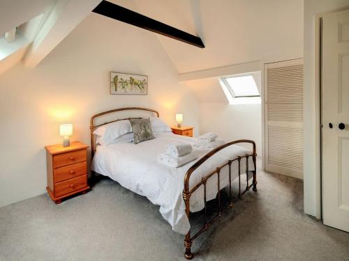 a bedroom with a bed and two night stands and two lamps at Old Chapel Cottage in Dunster