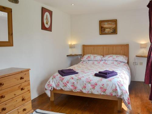 Un dormitorio con una cama con toallas moradas. en The Garden Barn, en Ivybridge