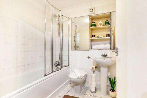 a bathroom with a shower toilet and a sink at Park Lane Apartments Marble Arch in London