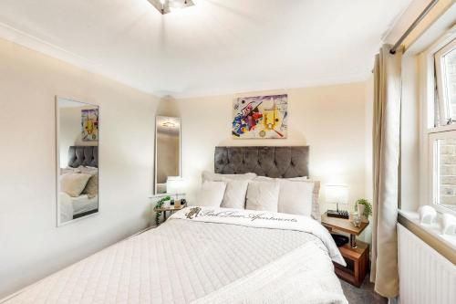 a white bedroom with a large bed and a window at Park Lane Apartments Marble Arch in London