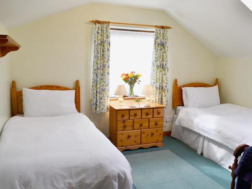 a bedroom with two beds and a window at Holly Cottage in Richmond