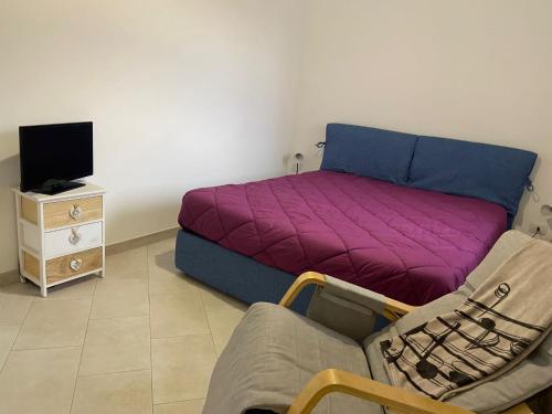 a room with a bed and a couch and a tv at Villino Monte Sant'Angelo in Otranto